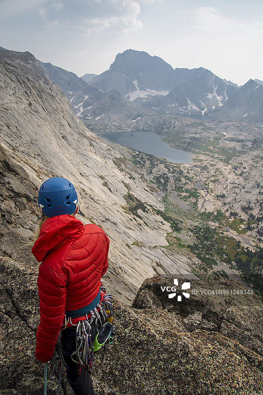 站在悬崖上面对天空的登山装备女性徒步旅行者图片素材