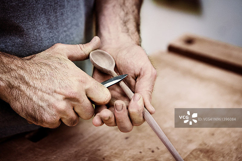 在车间用刀雕刻木勺的木匠图片素材
