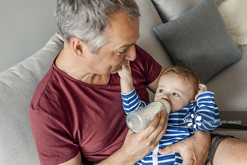 父亲用奶瓶喂孩子照片图片素材