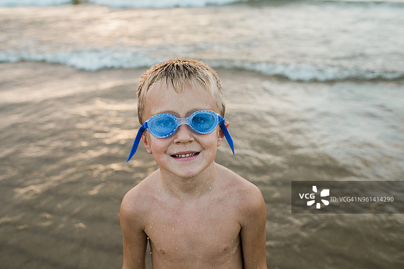 海滩边，戴着游泳镜的赤膊男孩肖像图片素材