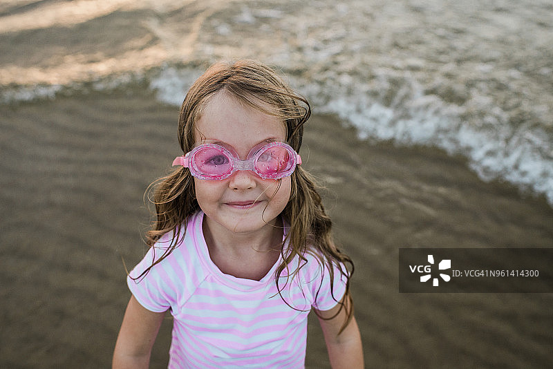 海滩边戴游泳镜的可爱女孩人像图片素材