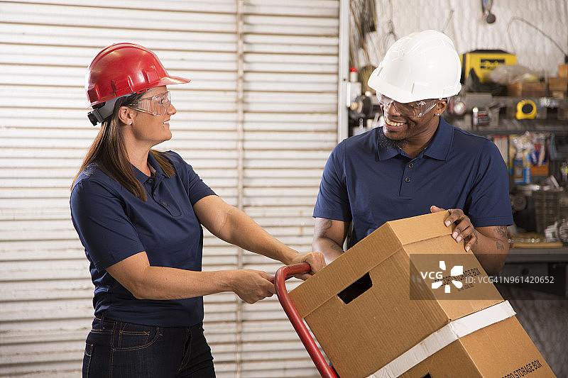 产业工人在仓库内搬运箱子图片素材