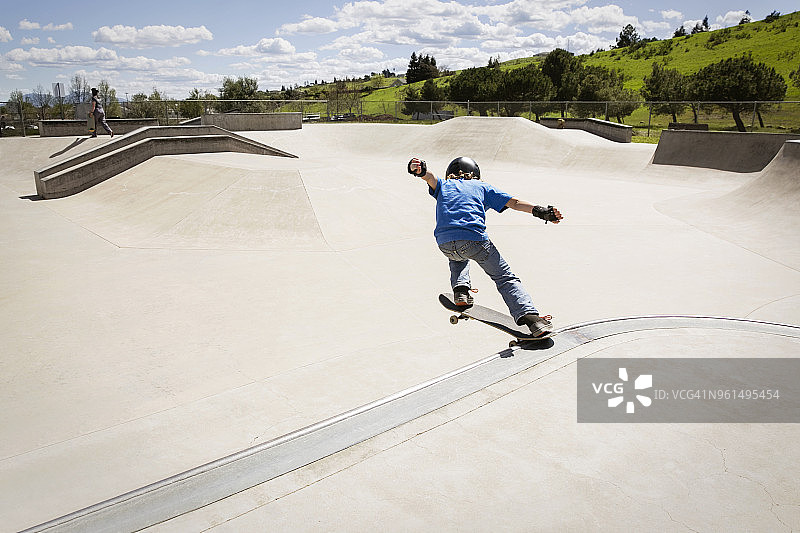 高角度拍摄的男孩在滑板坡道上表演特技图片素材