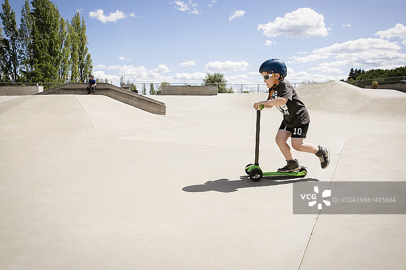 男孩在滑板公园玩滑板车图片素材