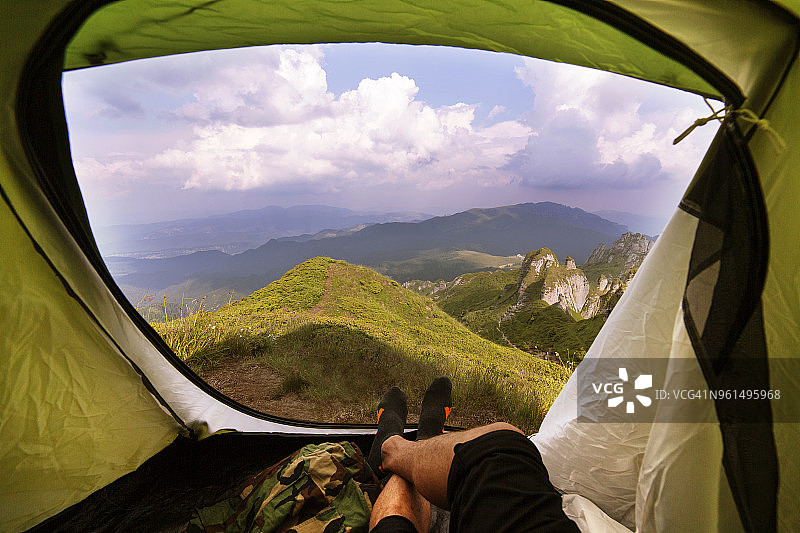 男人躺在帐篷里靠着山脉的下半身视角图片素材