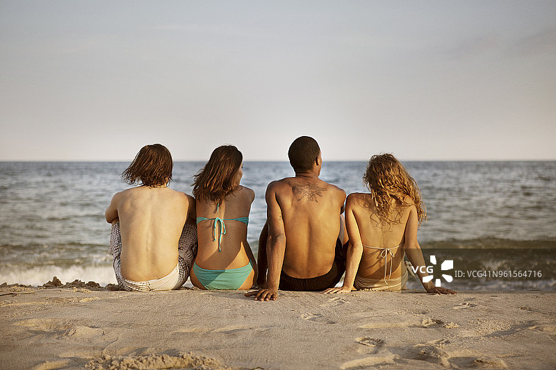 朋友们坐在海滩上的背影图片素材