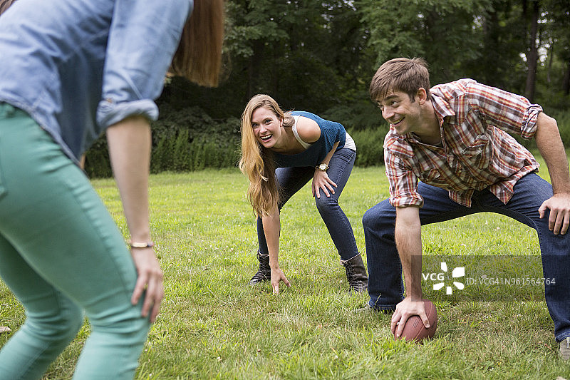 男人拿着足球，看着草地上女性朋友图片素材
