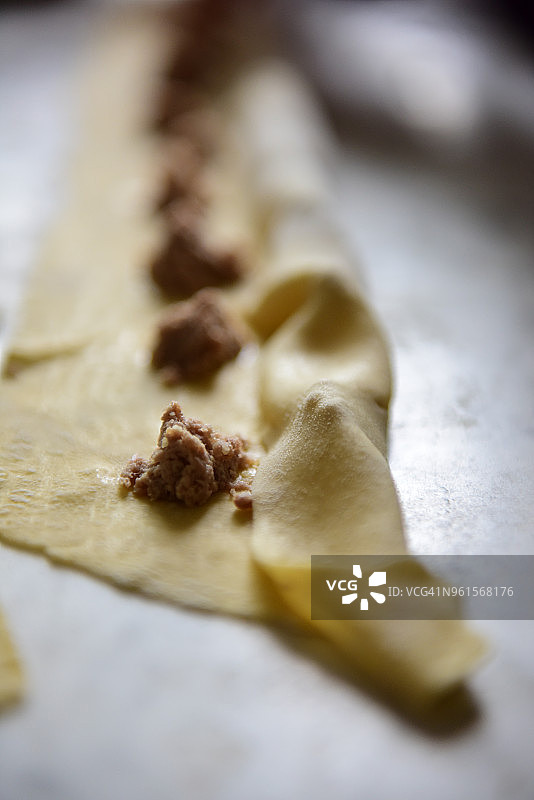 新鲜的意大利面皮上排列着少量馅料，用于制作意式饺子图片素材