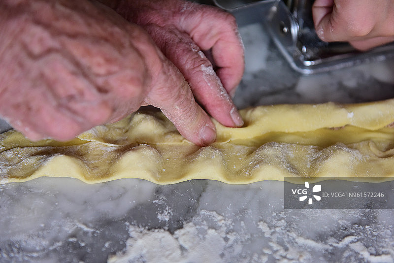 按压新鲜的意大利面皮制作意大利饺子图片素材