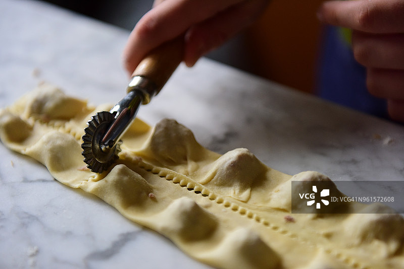 使用面食切割轮分离面食包裹，制作意大利饺子图片素材