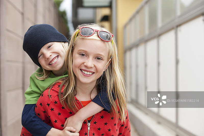 快乐女孩背着哥哥的肖像图片素材