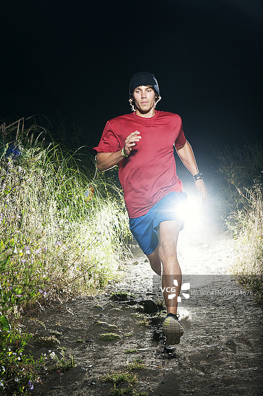 在夜晚的田野上跑步的男人图片素材