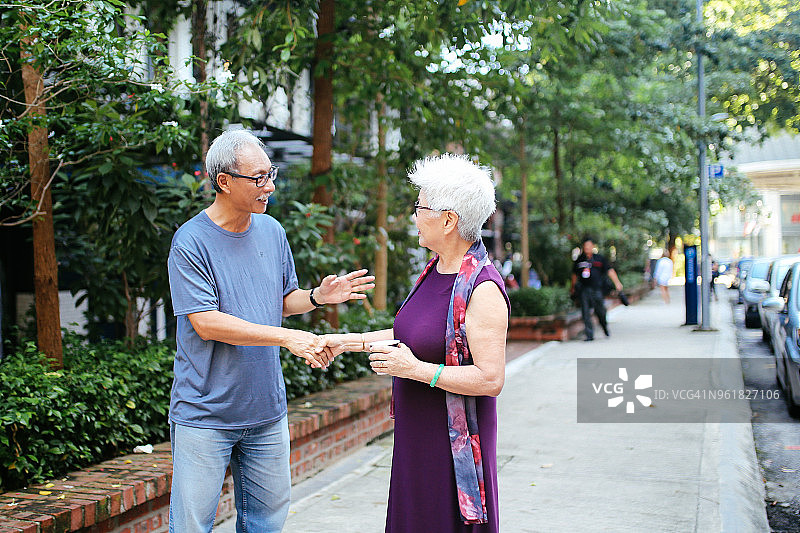 年长的男人和女人在马来西亚吉隆坡的街道上交谈图片素材