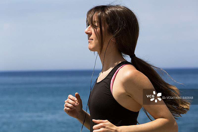 年轻长发女子在海边奔跑图片素材