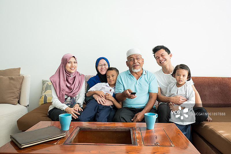 马来西亚家庭在沙发上看电视图片素材