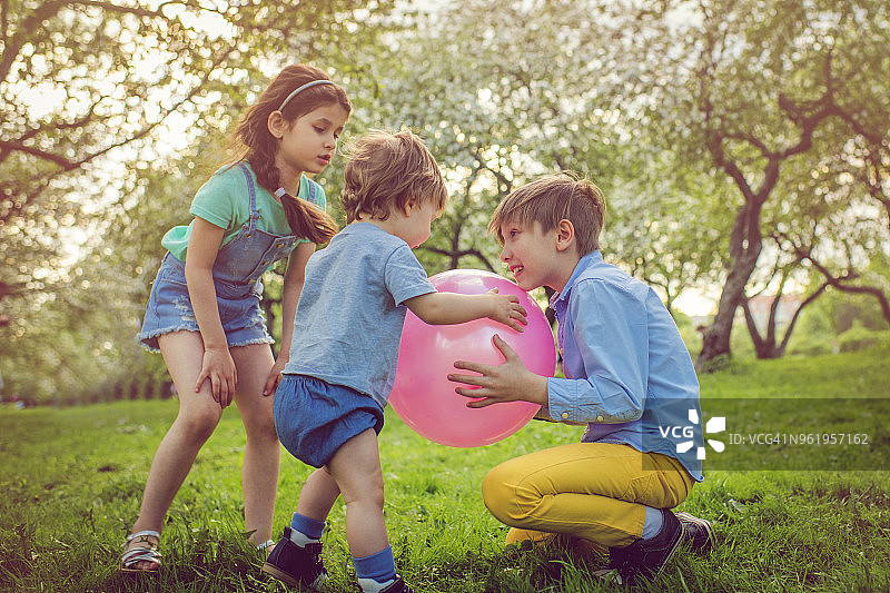 小男孩和女孩与弟弟一起玩球图片素材