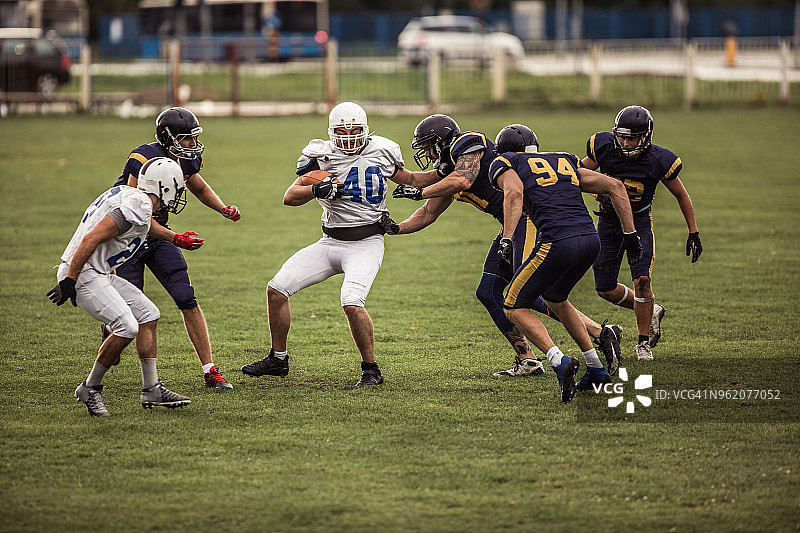 橄榄球场上比赛中的一群美式橄榄球运动员图片素材