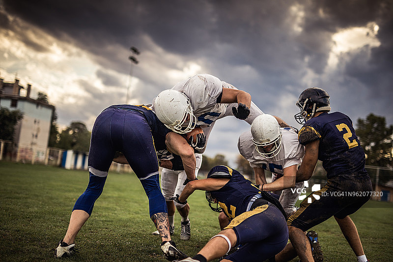 努力突破防守的橄榄球运动员图片素材