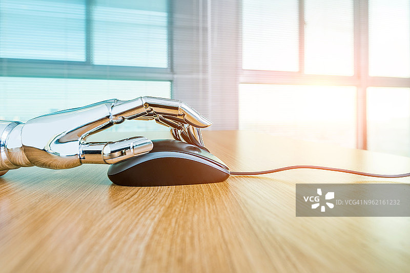 机器人手使用电脑鼠标图片素材