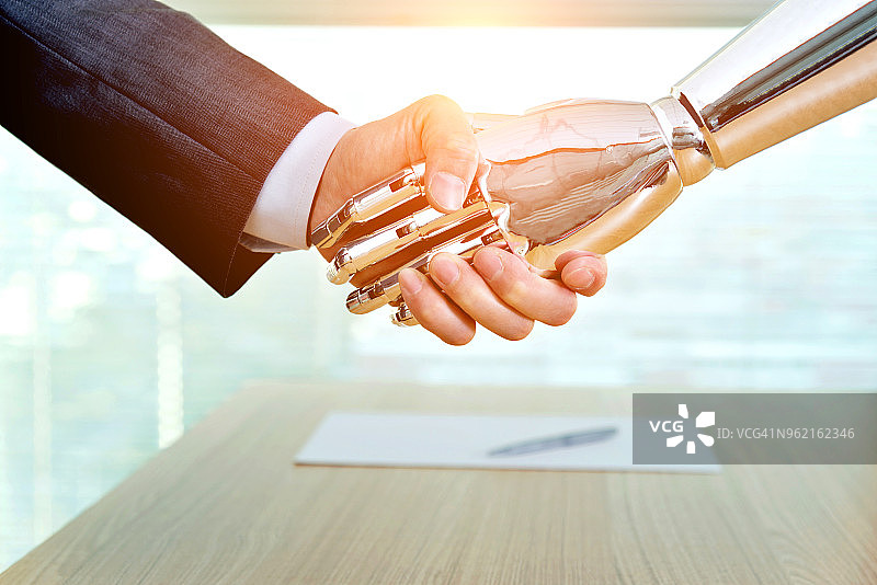 商人和机器人室内握手图片素材