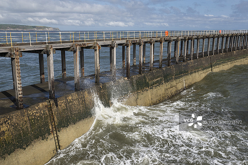 英格兰北约克郡惠特比港西码头上的海浪图片素材