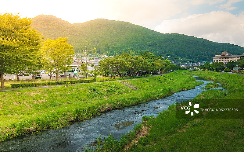 由布院乡间小路穿过的绿色稻田图片素材