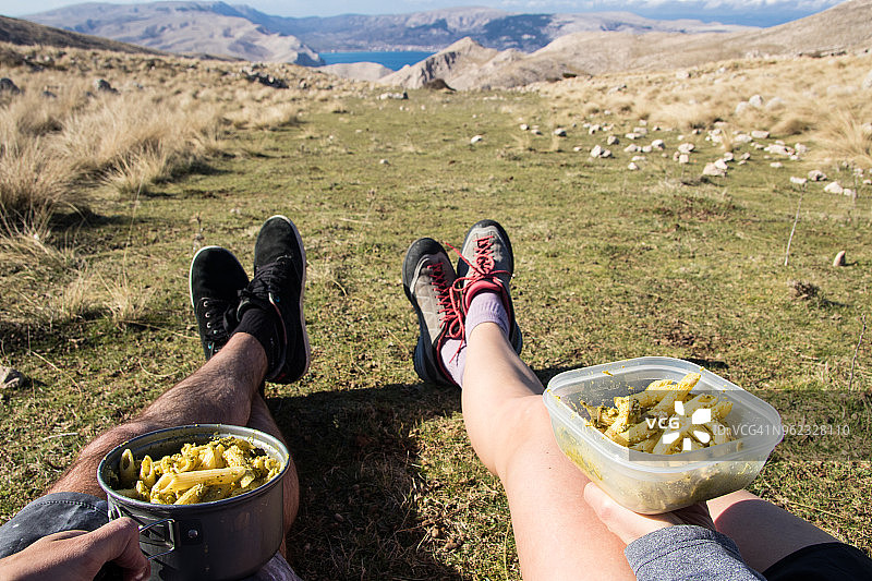 男女坐在草地上拿着香蒜酱意大利面图片素材