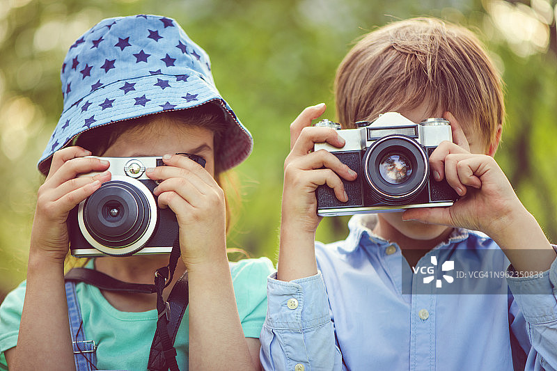 在公园里拍照的小男孩和女孩图片素材