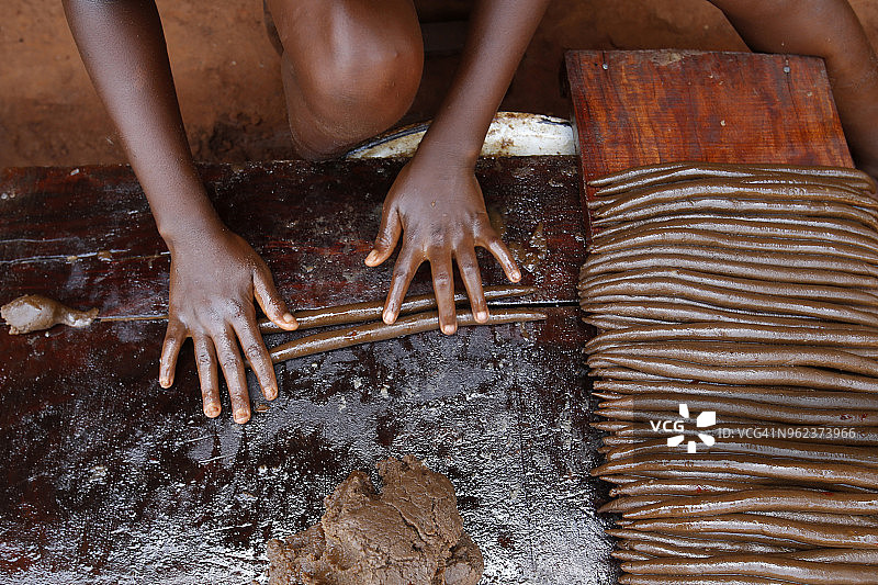贝宁祖省村庄里制作花生棒的儿童图片素材