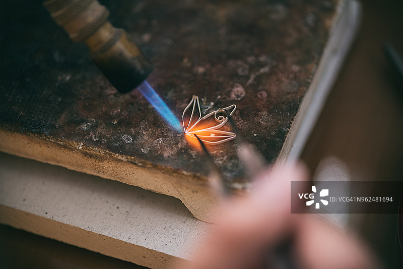 手持焊枪焊接银器的女人图片素材