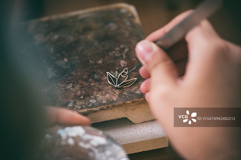 在工作室制作银饰的女性珠宝匠图片素材