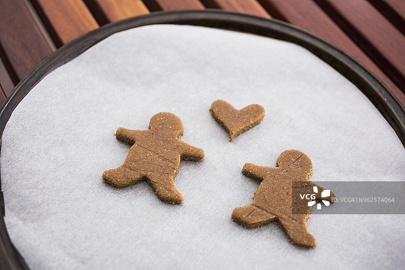 姜饼夫妇和心形饼干烘焙纸高角度视图图片素材