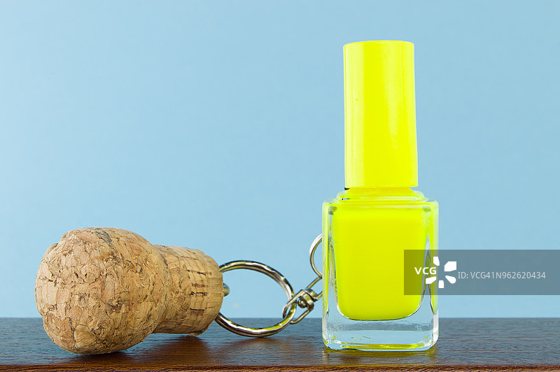拿着黄色指甲油的卡瓦软木钥匙圈图片素材