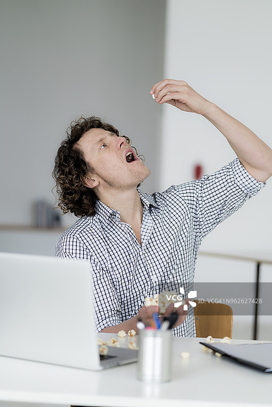 商人在办公室吃爆米花图片素材
