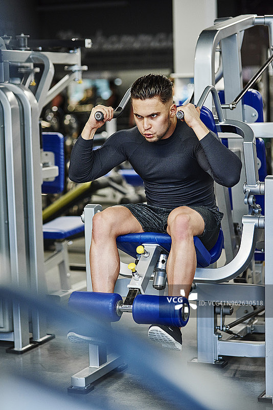 男子在健身房使用器械训练图片素材