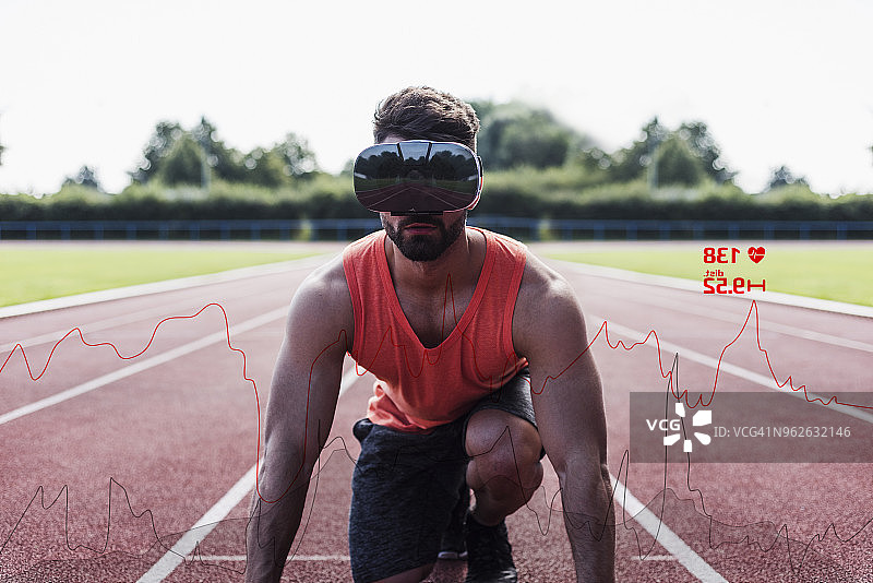 运动员在田径跑道上处于起跑姿势，戴着VR眼镜，周围环绕着数据图片素材