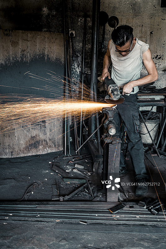 铁匠在车间使用电动工具图片素材
