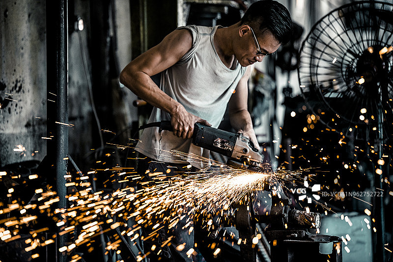 铁匠在车间使用电动工具图片素材