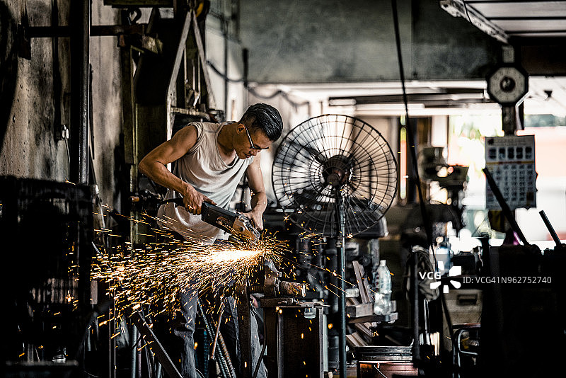 铁匠在车间使用电动工具图片素材