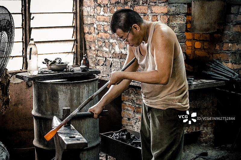 铁匠用锤子塑造铁图片素材