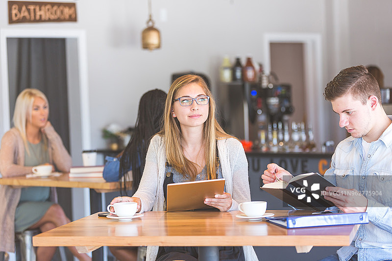 大学生在咖啡店的桌子旁学习图片素材