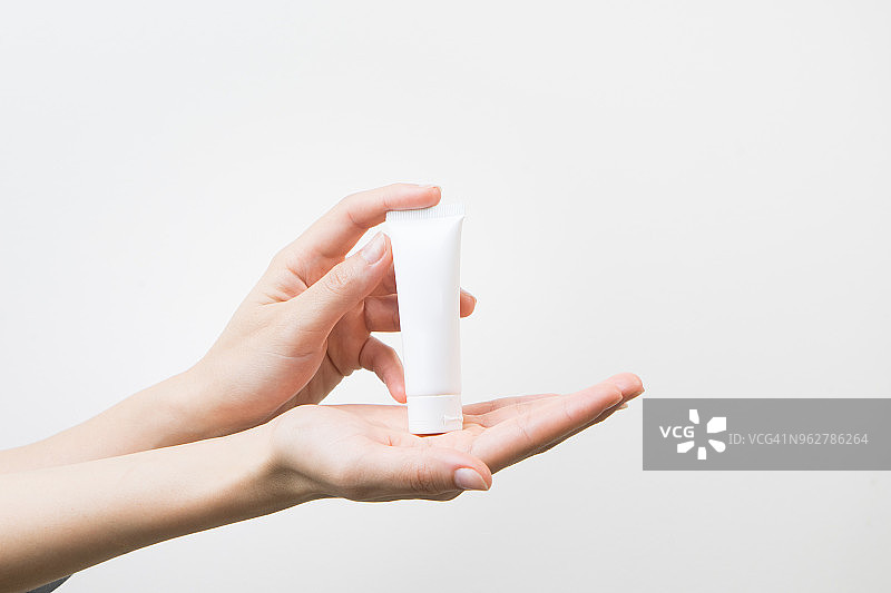 手持护肤霜瓶和润肤乳化妆品图片素材