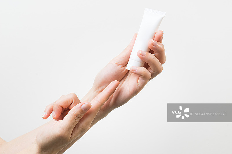 手持护肤霜瓶和润肤乳化妆品图片素材