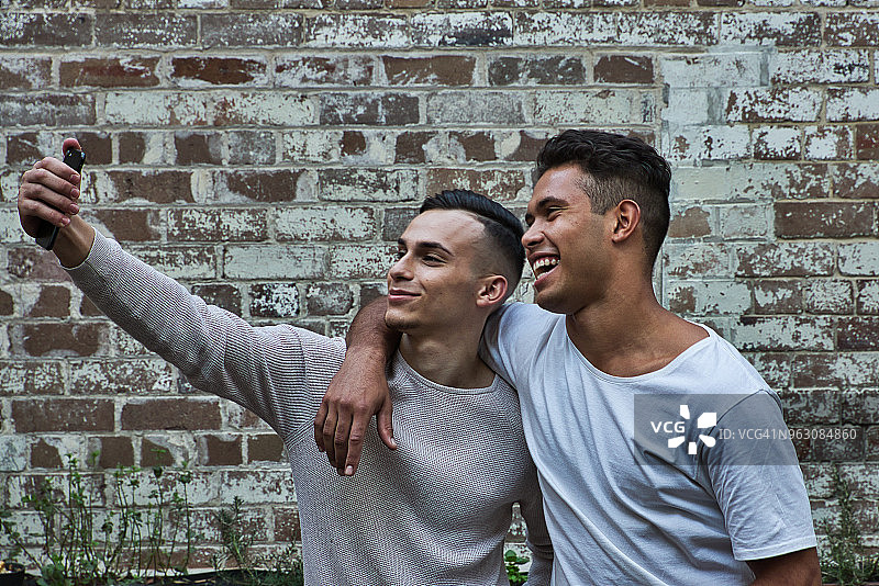 两名休闲着装男模特黄昏悉尼手持手机图片素材