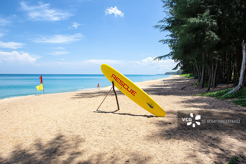 迈考海滩沙滩上的橙色救生板和边界旗图片素材
