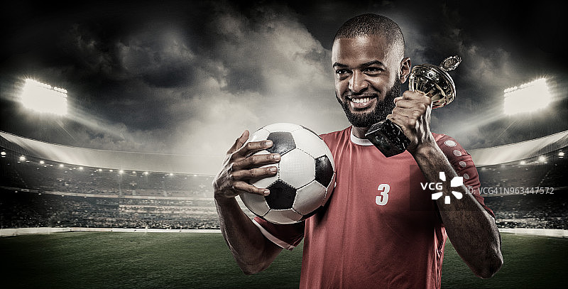 阿拉伯裔穆斯林足球运动员在体育场灯光前手持足球图片素材