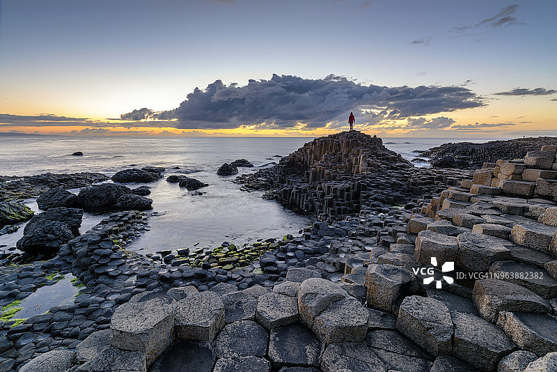 男人观看玄武岩柱上的日落图片素材