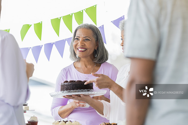 女人捐赠巧克力蛋糕用于义卖图片素材