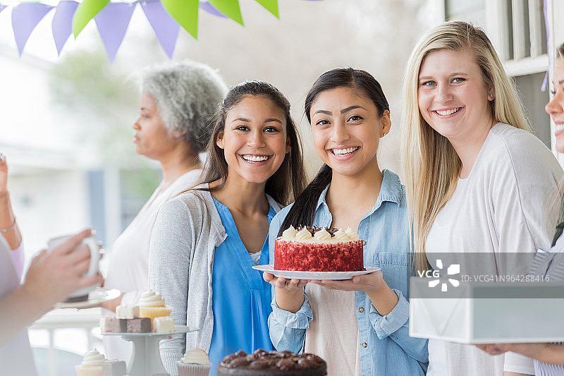 妇女在义卖会上购买蛋糕图片素材