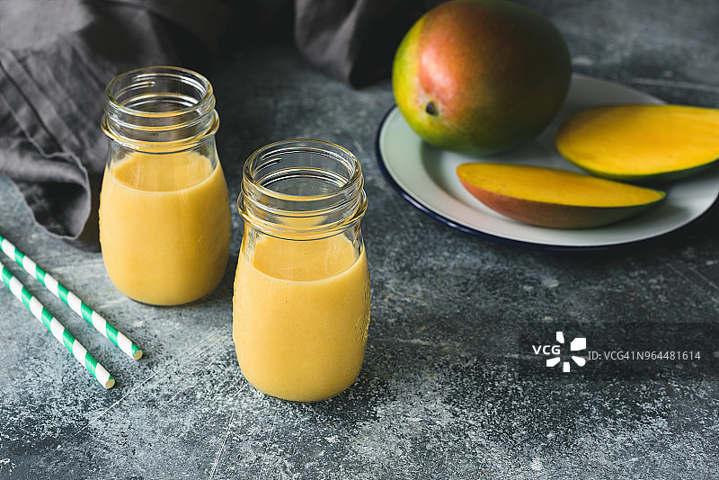 混凝土背景上的瓶装芒果冰沙图片素材